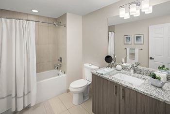 A modern bathroom with a white shower curtain and a white toilet.